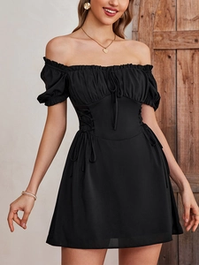 Detail of corset-style lace-up waist and ruffled bust on a black puff sleeve mini dress