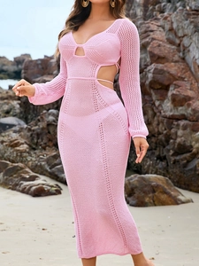Detail of pink crochet knit maxi dress with side cut-outs and lace-up straps on the beach