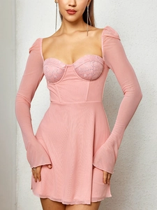 Dettaglio mini abito in rete rosa con corpetto in pizzo floreale e maniche lunghe velate