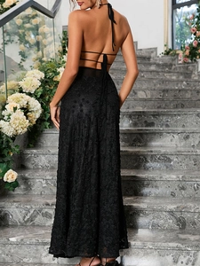 Détail du dos de la robe longue en dentelle noire avec bretelles croisées et roses en relief