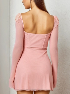 Dettaglio del mini abito in rete rosa con schiena scoperta e struttura a corsetto