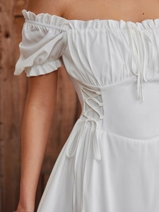 Close-up of white puff sleeves and side drawstring tie detail on an A-line mini dress