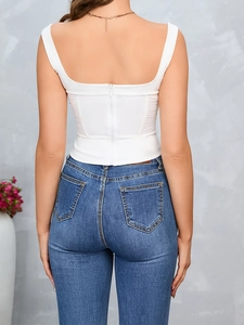Detail of white corset top featuring back zipper closure and sheer mesh side panels