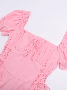 Detail of pink puff sleeve dress showing square neckline and side lace-up design