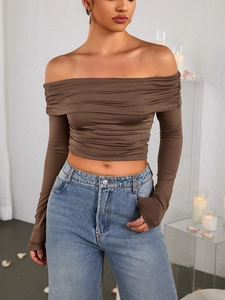 Detail showing deep brown off-shoulder long sleeve crop top with elegant ruched textures
