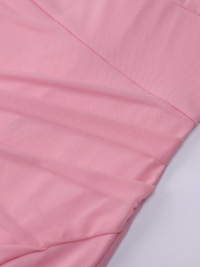 Détail macro du tissu en maille rose montrant la texture délicate et le design plissé