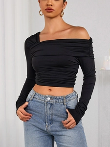 Détail du haut court noir à épaules dénudées avec texture froncée et coupe ajustée
