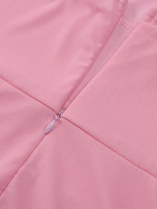 Gros plan sur la fermeture éclair invisible d'une robe rose à manches longues en tulle