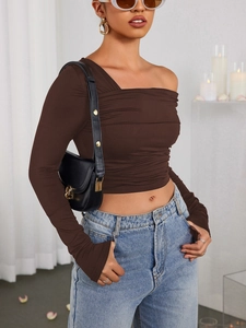 Détail du crop top froncé en soie de lait avec épaule asymétrique et manches longues