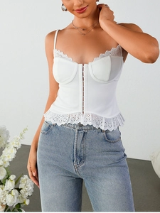 Détail de la broderie en dentelle blanche et fermeture à crochets sur le haut caraco