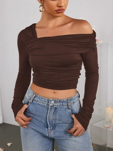 Détail du haut marron à épaules dénudées avec tissu plissé et coupe ajustée sexy