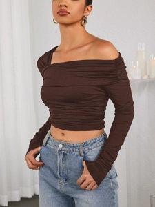 Détail du crop top marron chocolat à épaules dénudées avec plis et encolure asymétrique