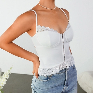 Corset blanc en dentelle avec broderie et agrafes porté avec un jean bleu clair