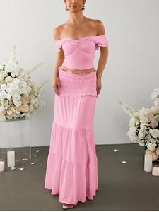 Detail of pink two-piece set featuring off-shoulder ruffled top and layered maxi skirt