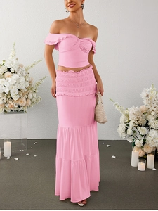 Detail of a pink ruffled crop top and high-waisted tiered maxi skirt set for women
