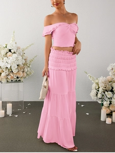 Detail of pink off-shoulder knot crop top and tiered ruffle maxi skirt set in romantic setting