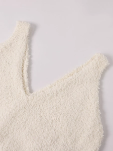 Vue détaillée du haut en maille blanc crème à col en V montrant la texture douce