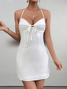Detail view of the intricate white lace trim and bodice of this halter neck mini dress