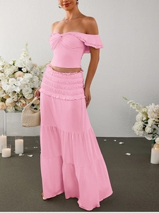 Detail of pink off-shoulder twist crop top and tiered maxi skirt with ruffles