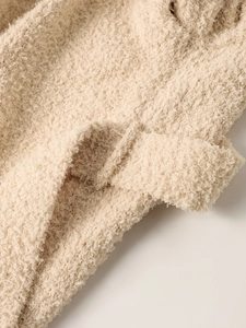 Close-up of soft cream popcorn knit fabric detail for women's winter hooded outerwear