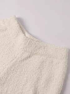 Gros plan sur le tissu en maille blanche douce et texture moelleuse de cet ensemble deux pièces