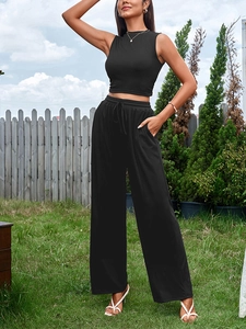Détail du pantalon large à taille haute avec cordon et crop top sans manches noir