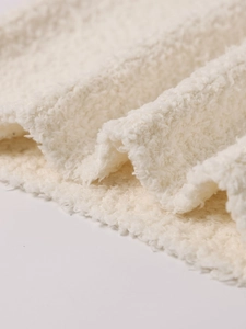 Détail rapproché de la texture du tricot sherpa blanc doux avec fibres bouclées