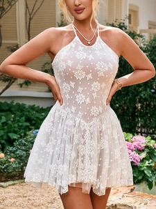 Close-up of intricate white floral lace bodice and layered mesh hem of halter neck dress