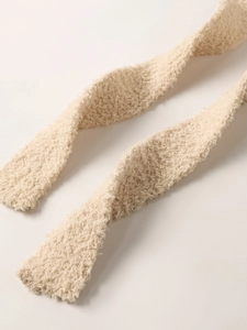 Close-up of plush beige knit fabric texture showing soft fuzzy material details