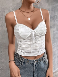 Close-up of white lace camisole featuring a sweet ribbon bow and scalloped lace trim