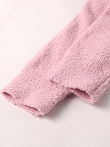 Close-up of soft pink sherpa fleece texture showing high-quality plush knit material
