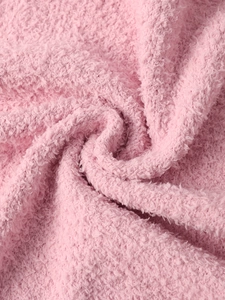 Macro shot of soft pink sherpa fleece fabric texture with cozy plush curly loops