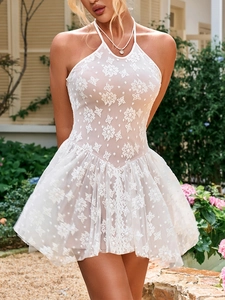 Detailed close-up of delicate floral lace pattern and halter neck on a white dress