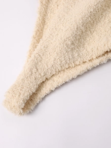 Détail du tissu en maille polaire corail beige montrant la texture douce et l'ourlet