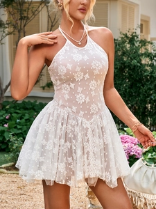 Close-up of white lace dress featuring intricate floral embroidery and layered tulle hem