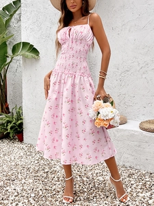 Détail de robe midi fleurie rose montrant la taille élastiquée et le décolleté à cordon
