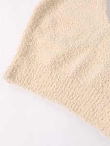 Gros plan détaillé sur la texture tricotée beige pelucheuse et le bord du vêtement