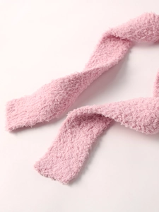 Close-up of soft pink knitted fabric with plush coral fleece texture for winter wear
