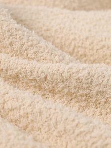 Détail macro de la texture douce en peluche sherpa crème pour ensembles en tricot