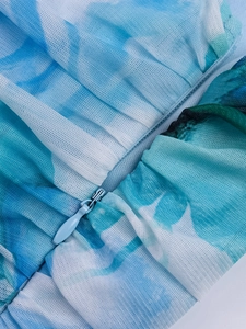 Detail view of invisible zipper and artistic blue mesh fabric on the back of the mini dress
