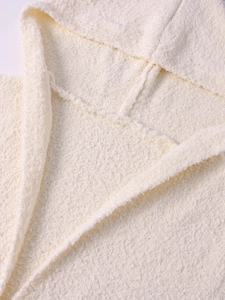 Close-up detail of soft cream fleece fabric and V-neck hooded design on a winter coat