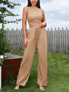 Détail du pantalon large taille haute avec cordon et texture en maille beige