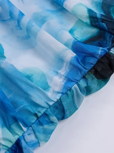 Detail of blue and white tie-dye mesh fabric with elastic ruching and precise stitching