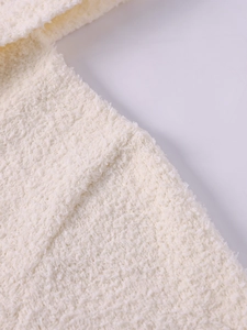 Detailed macro view of soft cream knitted fabric texture with plush loop pile finish