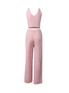 Détail d'un ensemble en tricot rose montrant la texture douce du haut et du pantalon large