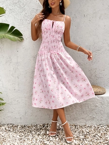 Détail du bustier smocké et des bretelles de la robe mi-longue d'été à fleurs roses