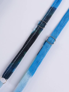 Detail of adjustable mesh shoulder straps with silver metal buckles on a printed dress