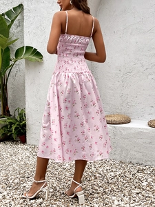 Détail d'une robe midi fleurie rose avec bustier smocké et fines bretelles