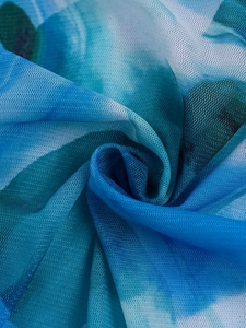 Close-up of blue and white gradient mesh fabric with a spiral texture and tie-dye pattern
