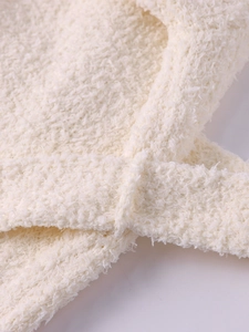 Close-up of plush fleece fabric texture and tie-waist detail on hooded winter coat